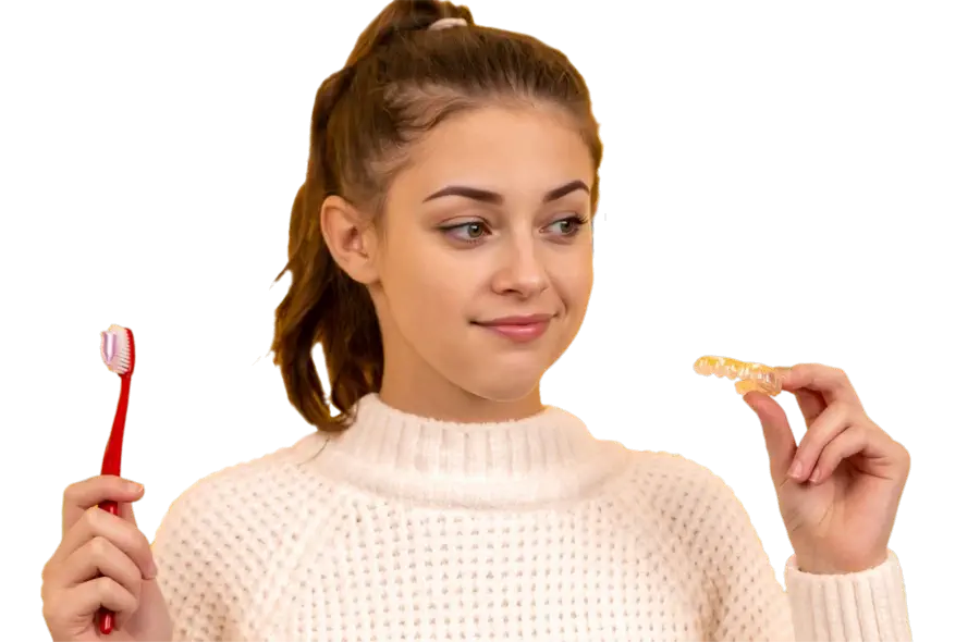 Young pretty female holding toothbrush and braces smiling and wondering about dental care