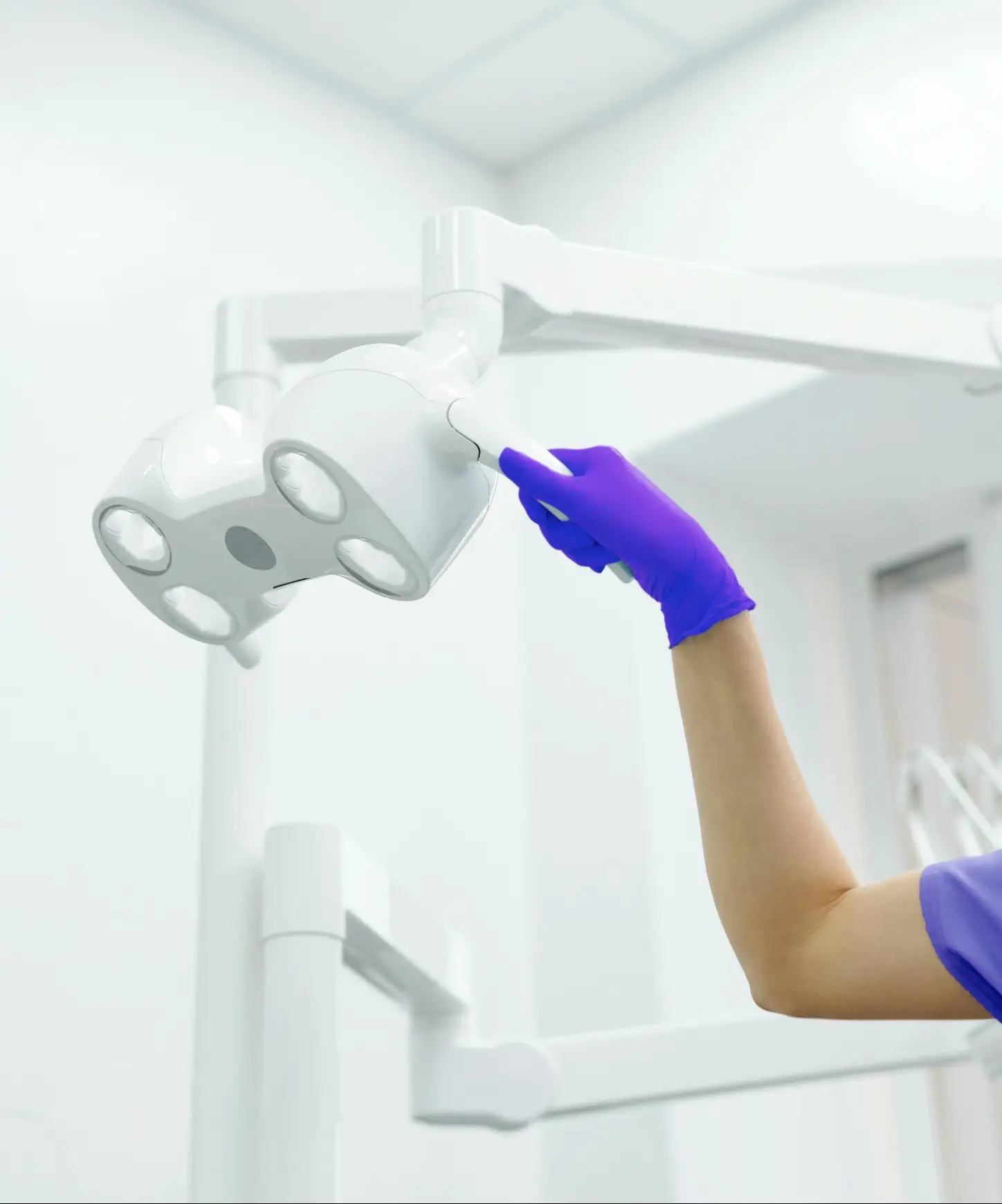 Dr. Green Tooth About Us Visual where a dentist with a purple gloves is adjusting the light on dental chair